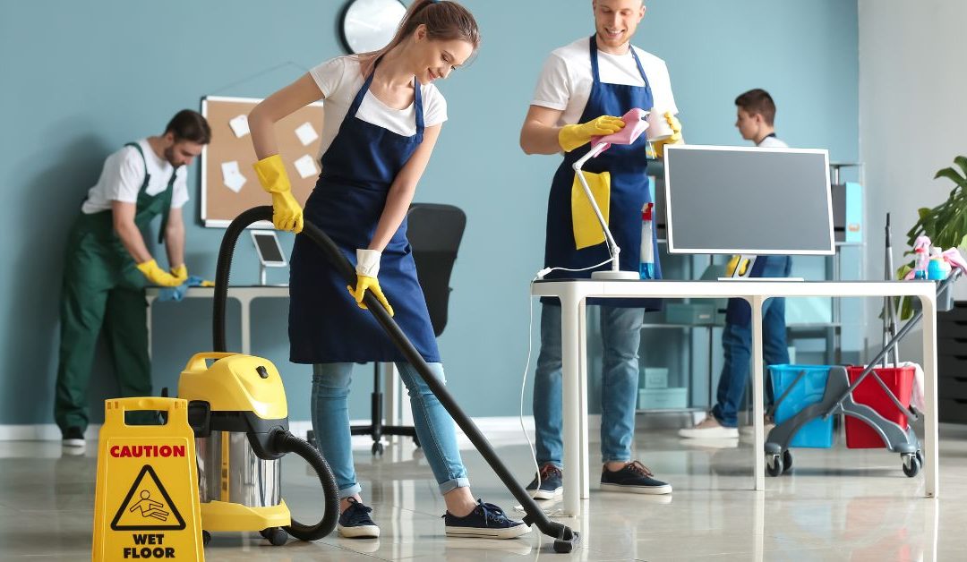 Genex Cleaning crew performing routine office cleaning tasks like vacuuming and disinfecting surfaces in a Michigan workplace