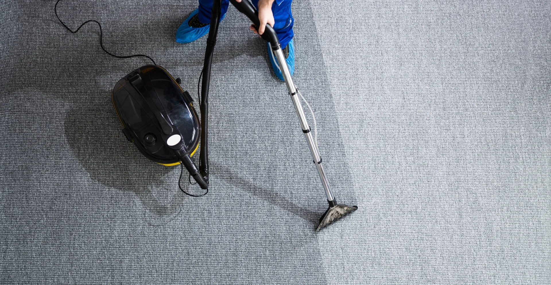 Technician using professional carpet extractor on office carpet